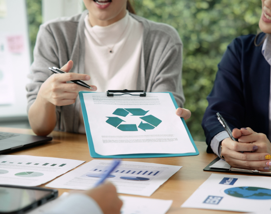 Uma mulher apresentando um projeto de economia circular em uma prancheta durante uma reunião.